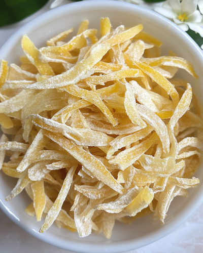 aviv8941_Candied_lemon_peels_in_a_bowl_on_a_table_on_a_white_ba_f8b99a0d-dd6d-4f65-9970-7b08045e6d85